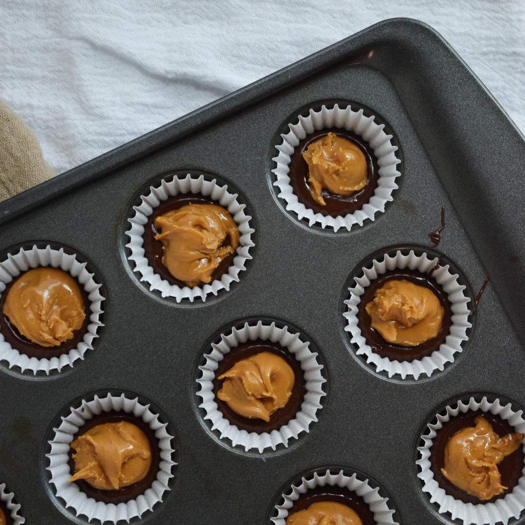 Melted chocolate and wowbutter filling in mini muffin tin